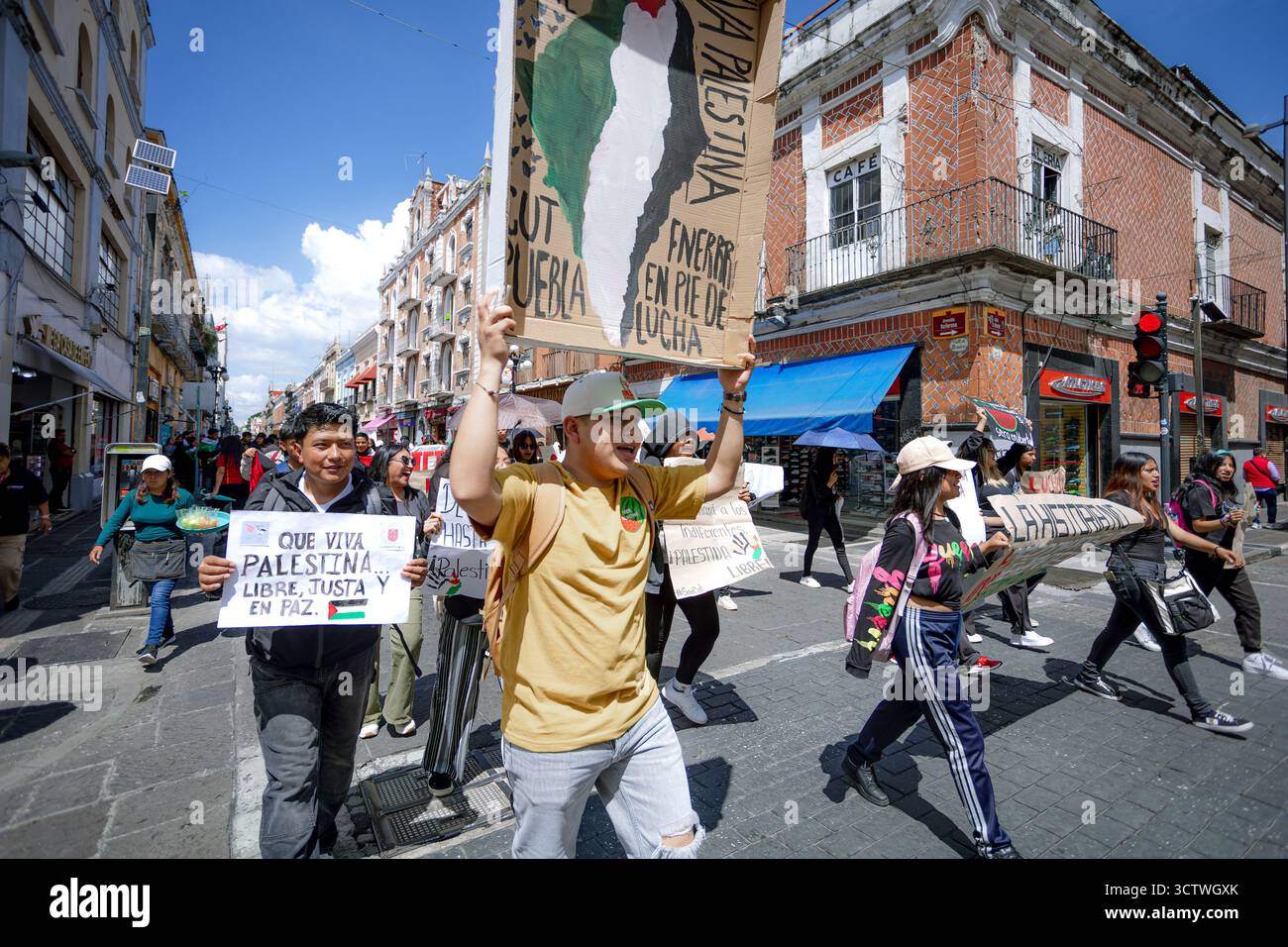 Un gruppo di studenti a Puebla marciano con segni e bandiere palestinesi, chiedendo libertà e denunciando il silenzio sul conflitto. Foto Stock