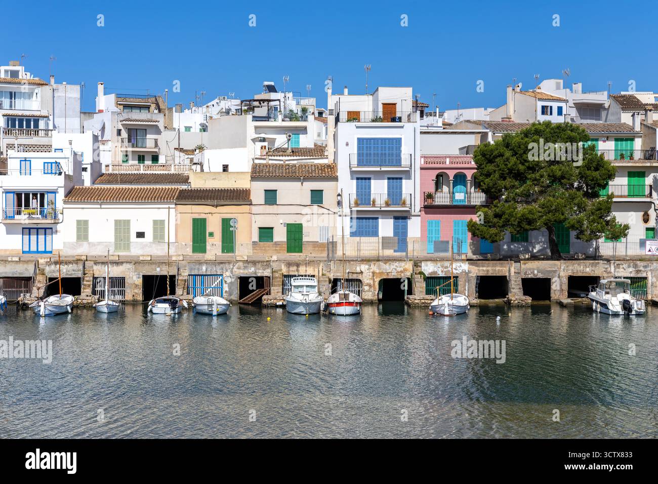 Case colorate nel villaggio di pescatori di Portocolom sull'isola di Maiorca con barche vacanze estive al mare in Spagna Foto Stock