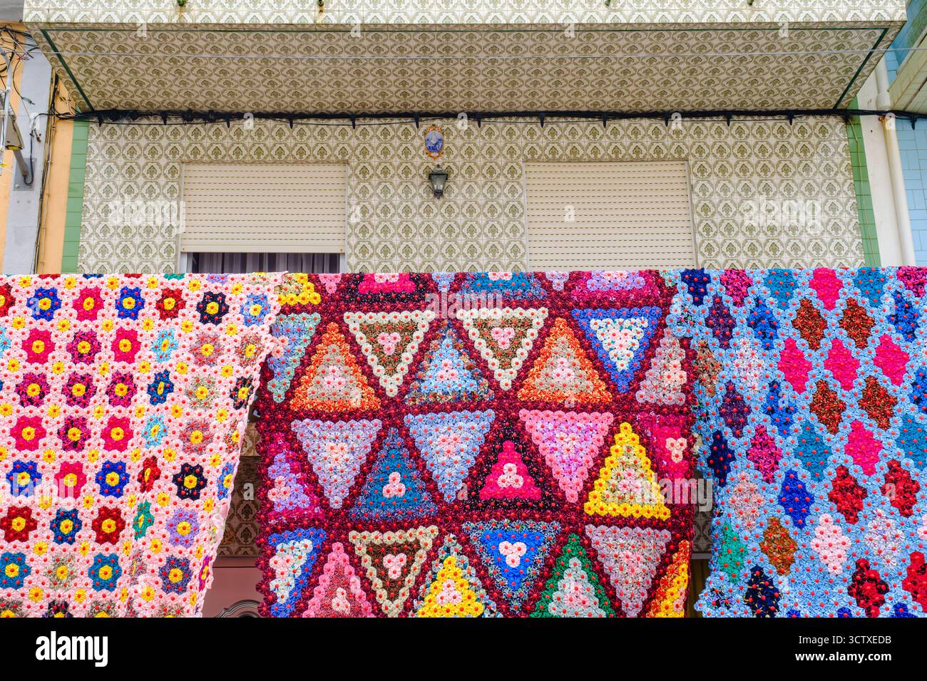 Balconi decorati con tessuti tradizionali, coperte, trapunte per il Festival dello Spirito Santo, villaggio di Ribeirinha, isola di Terceira, Azzorre, Portogallo Foto Stock