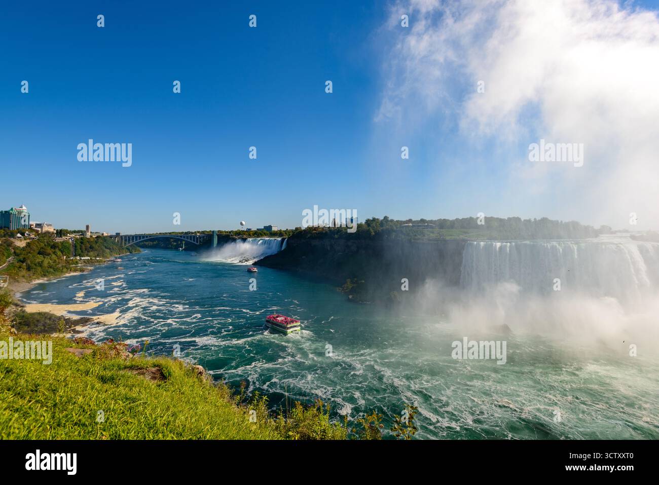 Una vibrante vista panoramica delle Cascate americane alle Cascate del Niagara, New York, con l'iconico Rainbow Bridge che collega gli Stati Uniti e il Canada nel Foto Stock