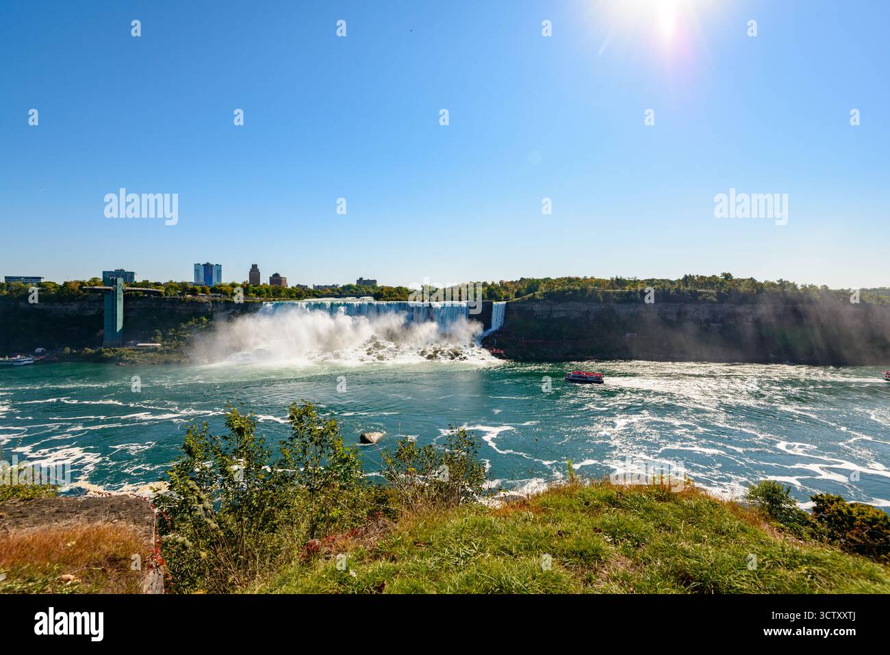 Una vibrante vista panoramica delle Cascate americane alle Cascate del Niagara, New York, con l'iconico Rainbow Bridge che collega gli Stati Uniti e il Canada nel Foto Stock