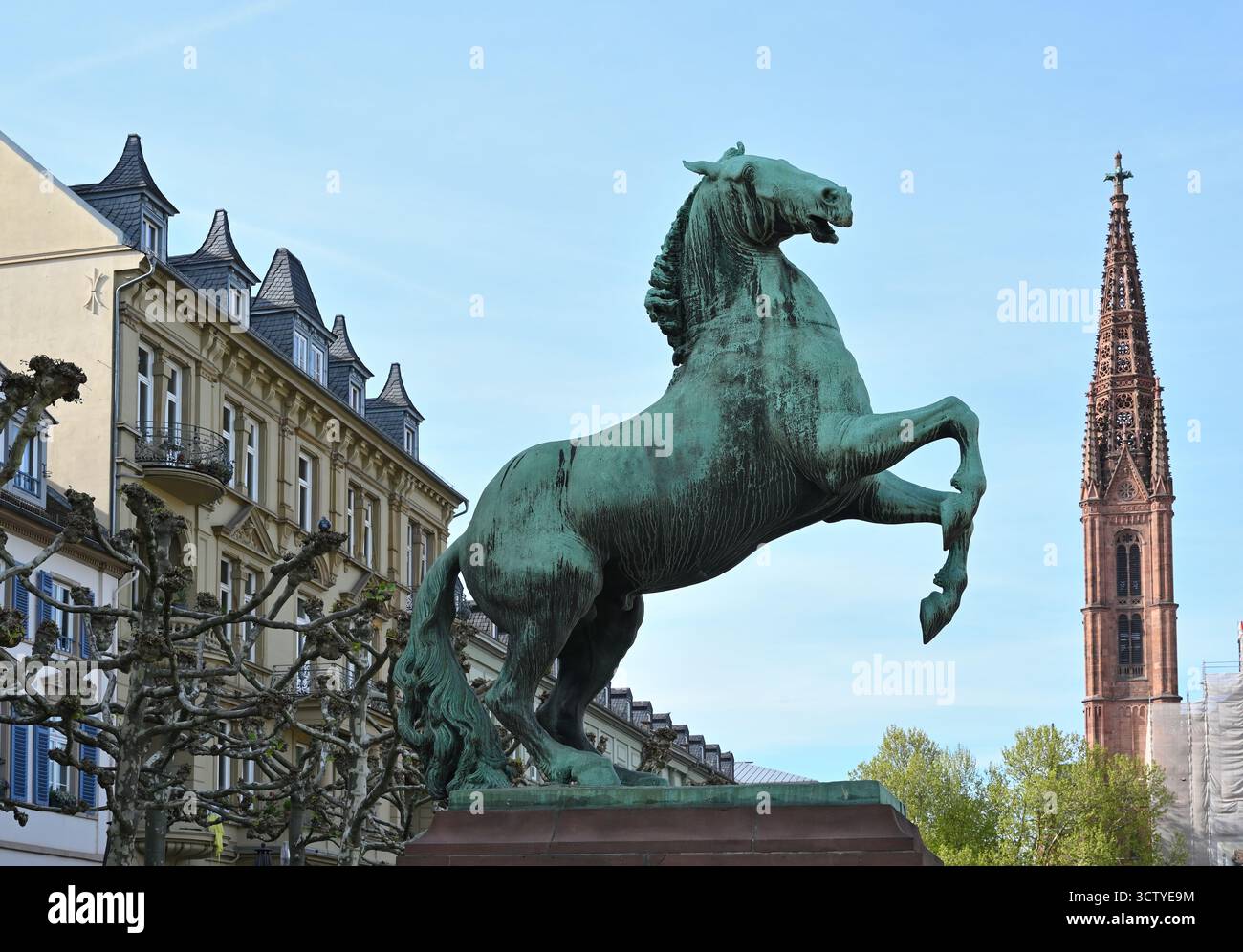 Chiesa del mercato e scultura a cavallo a Wiesbaden, Germania. La foto mostra le torri in mattoni rossi neogotici che si innalzano sopra la piazza, con un bronzo Foto Stock