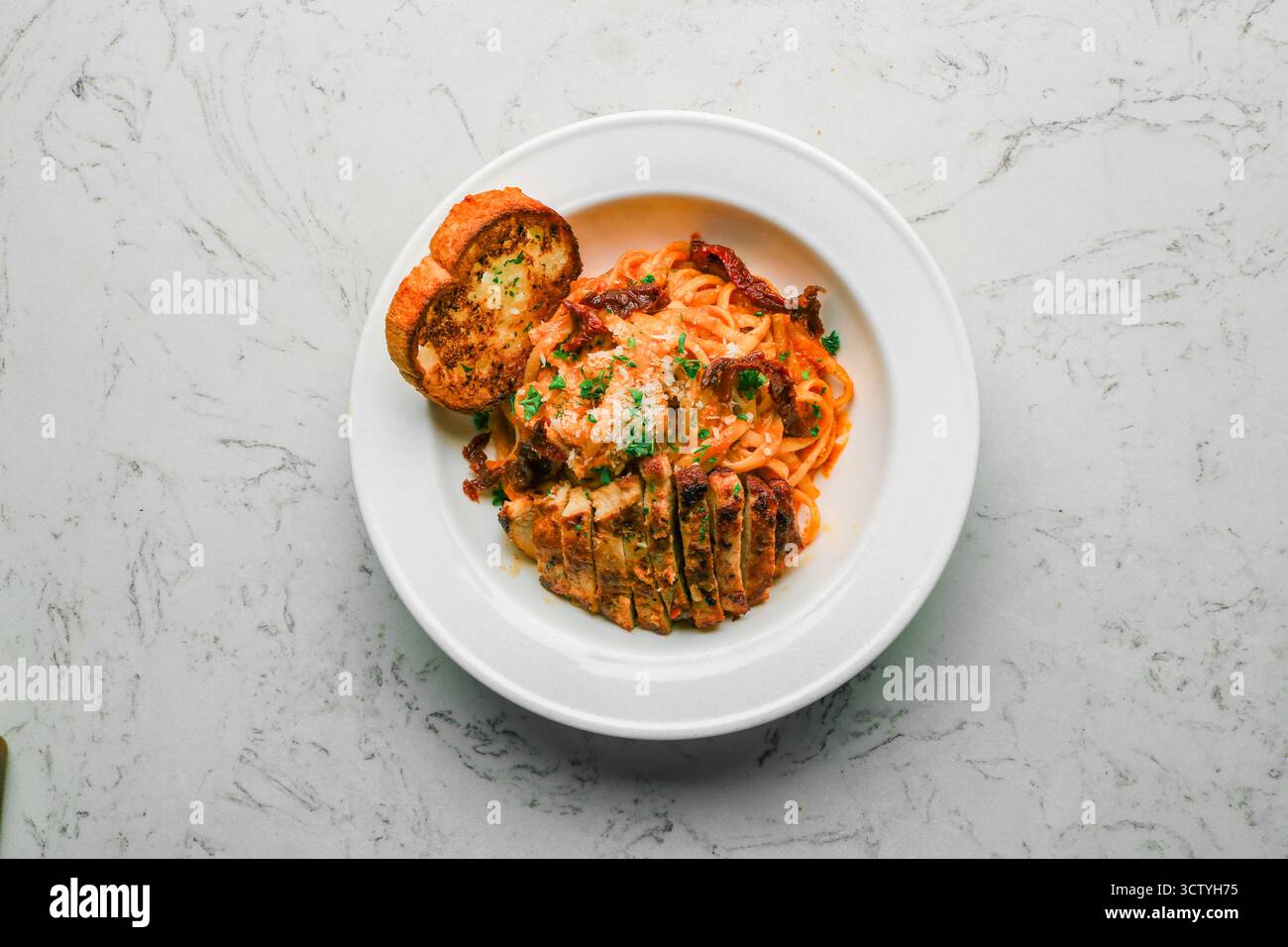 Linguine di pollo Pomodoro, pomodori secchi, base di pomodoro cremosa e parmigiano Foto Stock