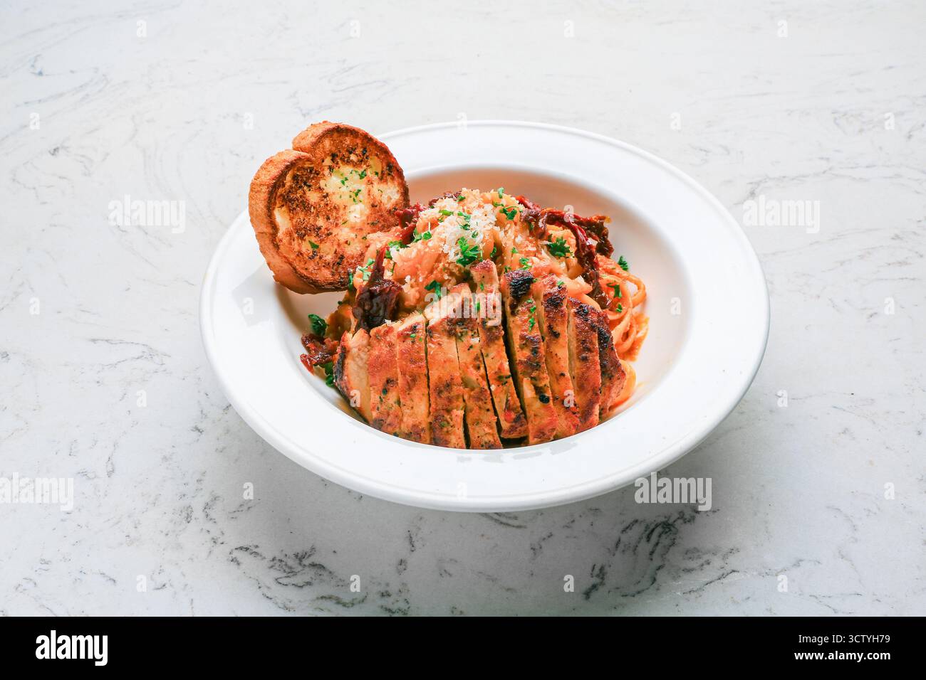 Linguine di pollo Pomodoro, pomodori secchi, base di pomodoro cremosa e parmigiano Foto Stock