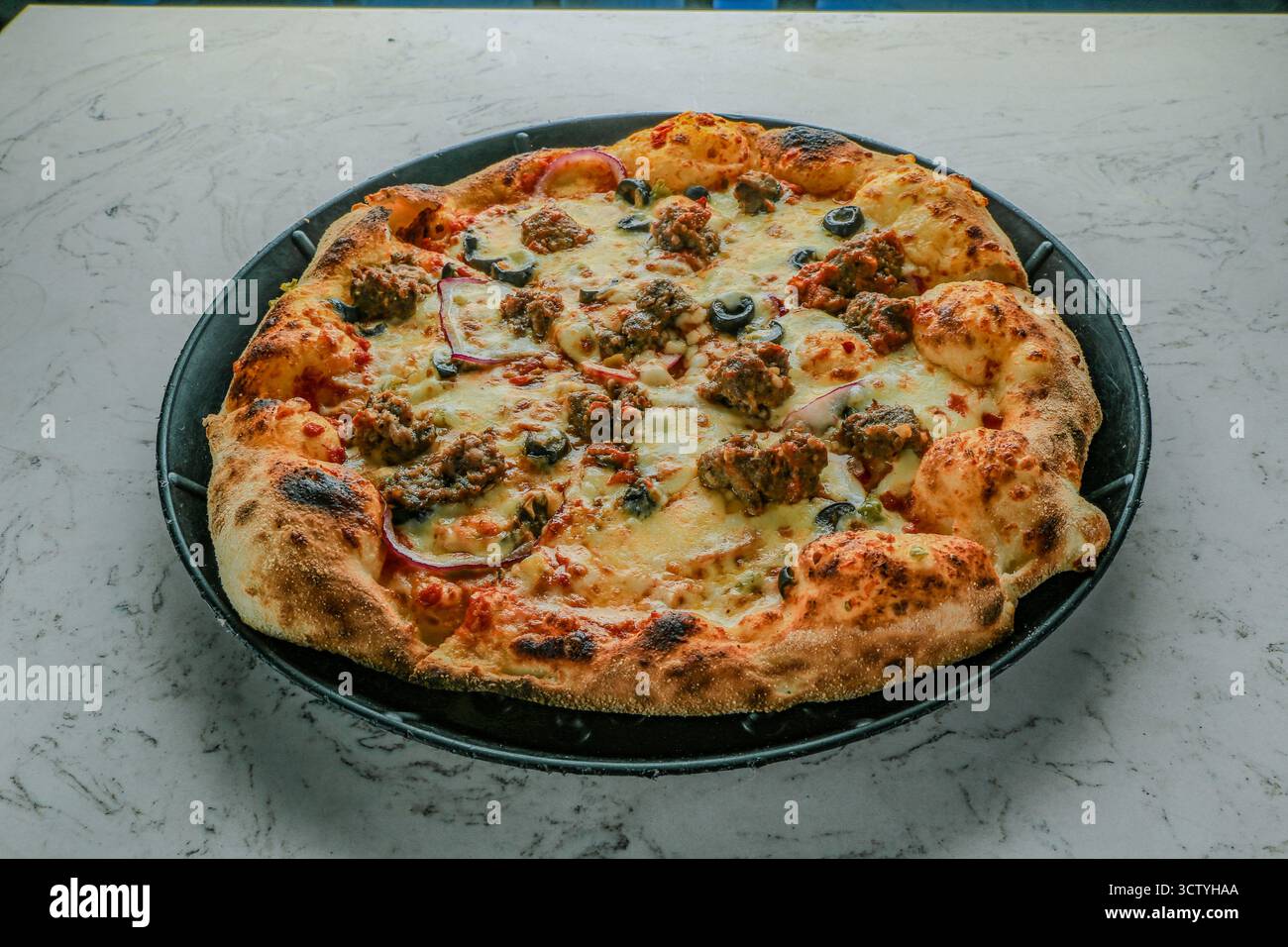 Polpette italiane bollite e condite con salsa Marinara, mozzarella, condite con cipolle, peperoni e olive. Foto Stock