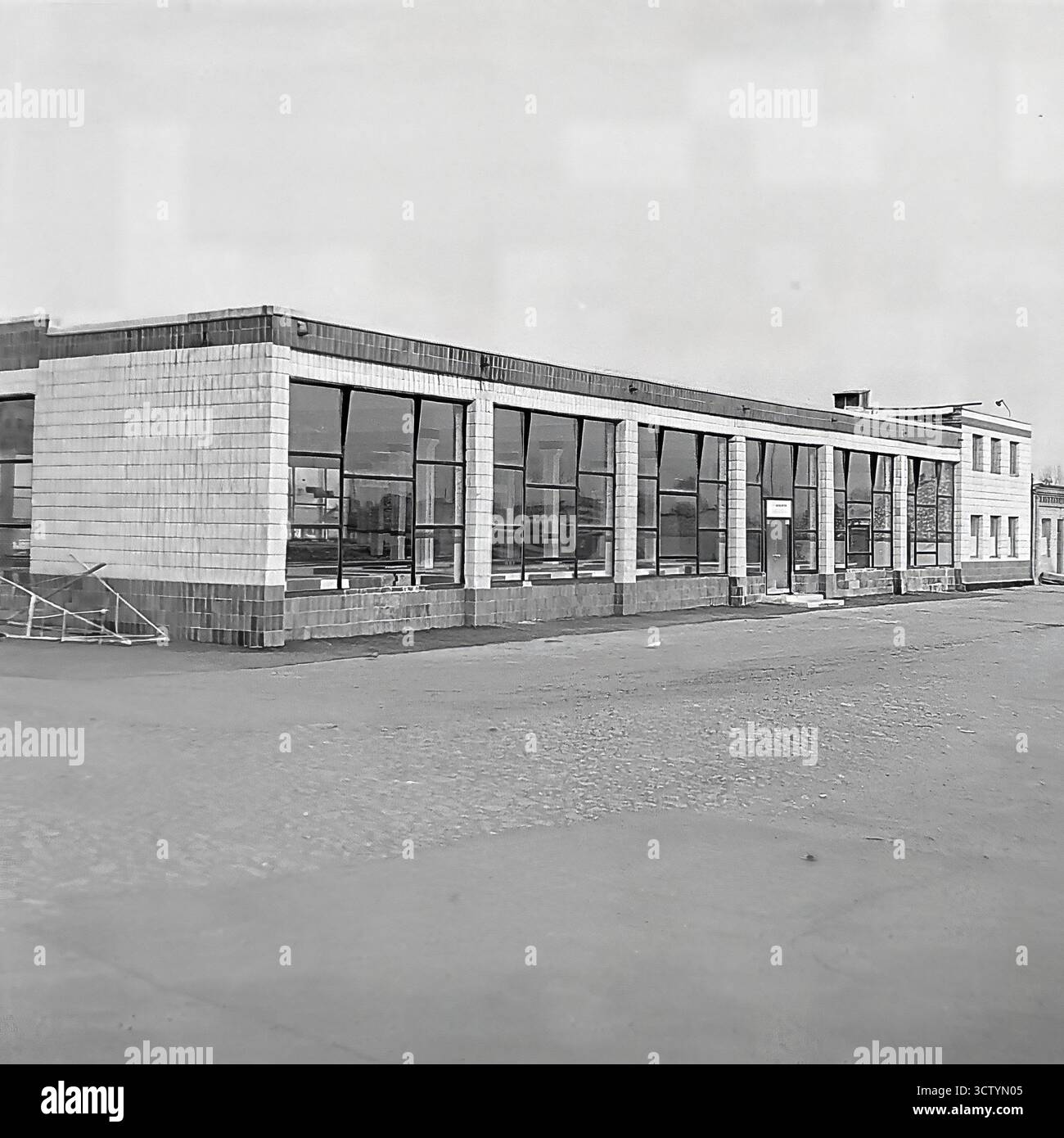 L'esterno di un nuovo mercato coperto a Sloviansk, la RSS Ucraina, viene catturato in questa foto architettonica in bianco e nero del 1970. Il lungo padiglione a un piano è un ottimo esempio di architettura modernista sovietica, caratterizzato da un tetto piatto, una facciata rivestita in piastrelle di colore chiaro e un motivo ritmico di grandi finestre panoramiche. L'estetica pulita, funzionale e geometrica dell'edificio è prominente. Questa immagine documenta un pezzo significativo di infrastruttura pubblica dell'era Brezhnev, mostrando lo stile e la portata dello sviluppo urbano Foto Stock