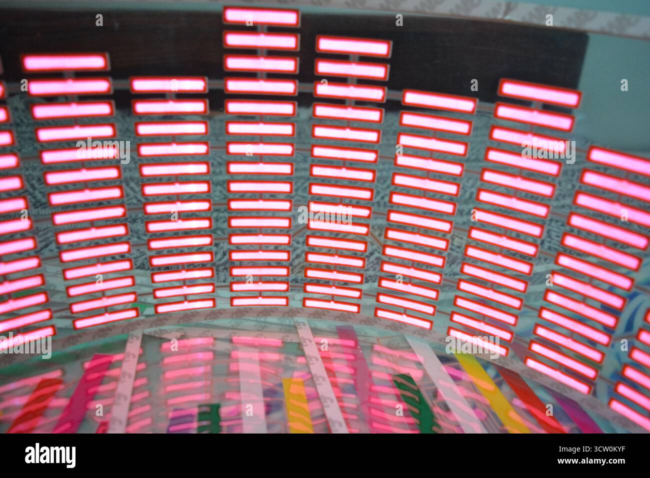 Adesivo di plastica rosso brillante a forma di equalizzatore che lampeggia in base alla musica. Tanti quadrati rossi luminosi su sfondo in plastica morbida, vivaci, Foto Stock