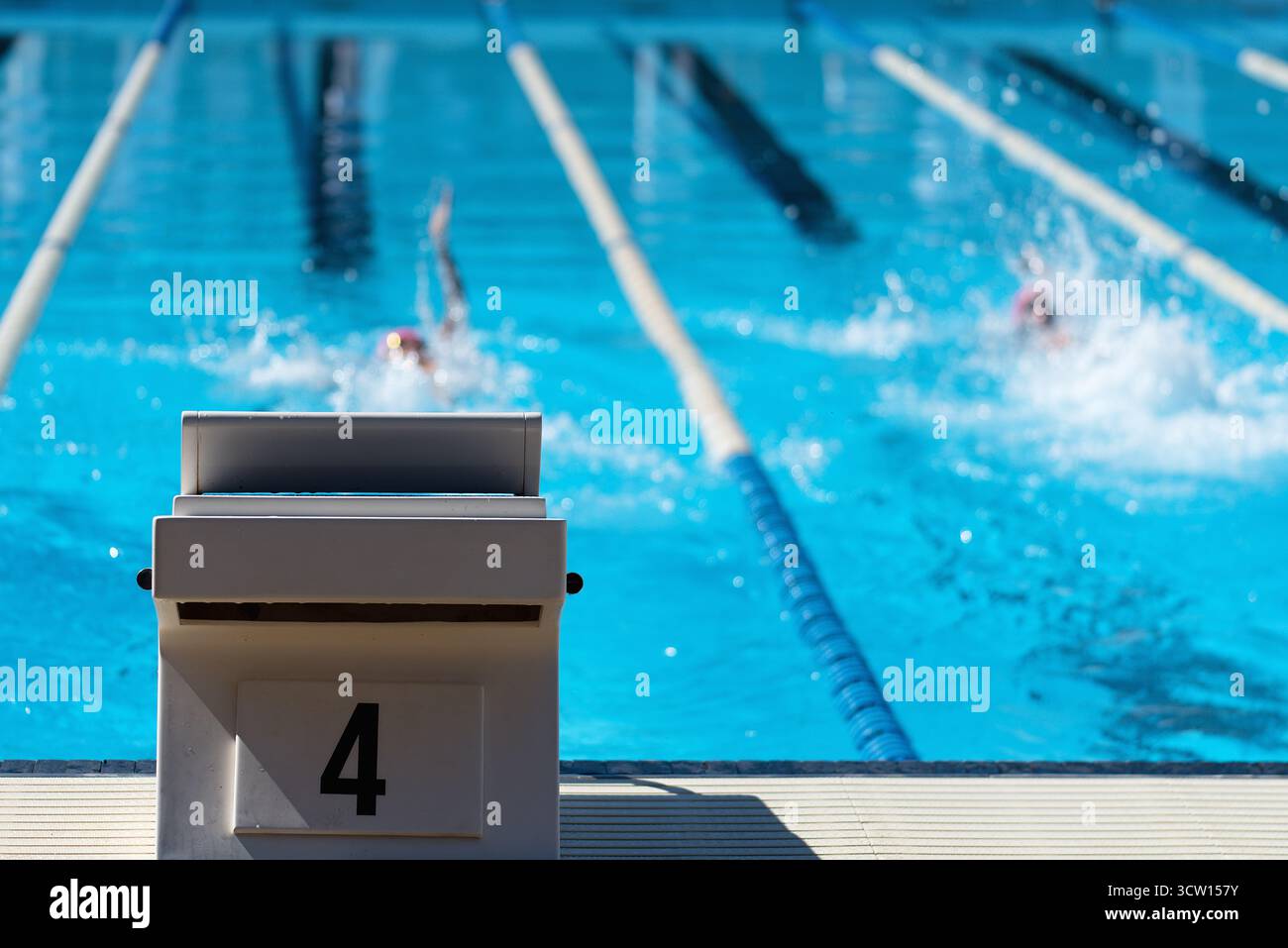 Dettaglio del blocco iniziale con il numero 4. Sullo sfondo i nuotatori stanno nuotando il dorso Foto Stock