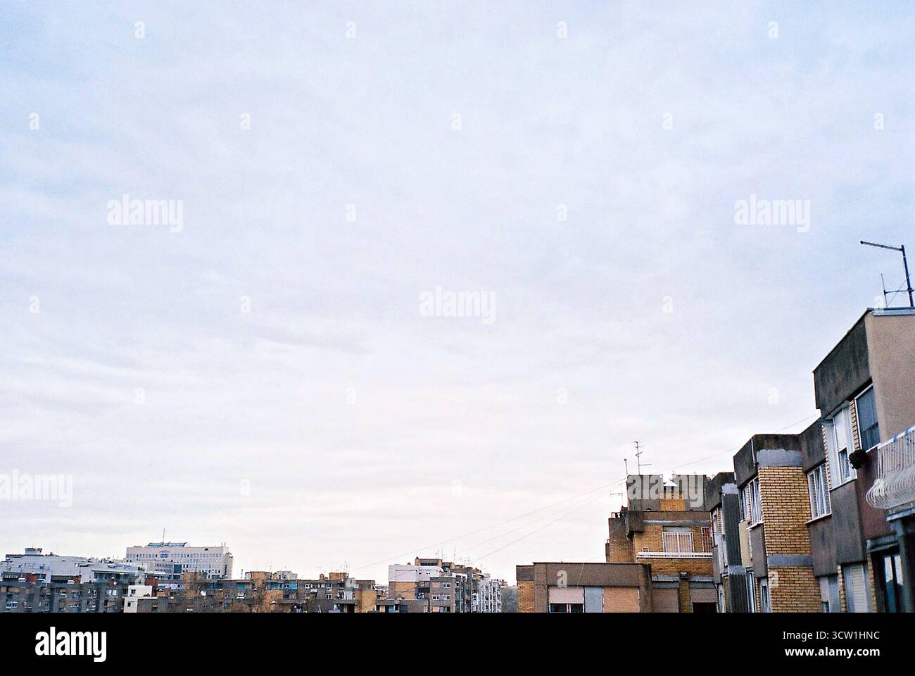Foto d'archivio analogica di tetti brutalisti in mattoni gialli sotto il cielo coperto. Forte spazio negativo e composizione minima. Architettura documentaria. Foto Stock
