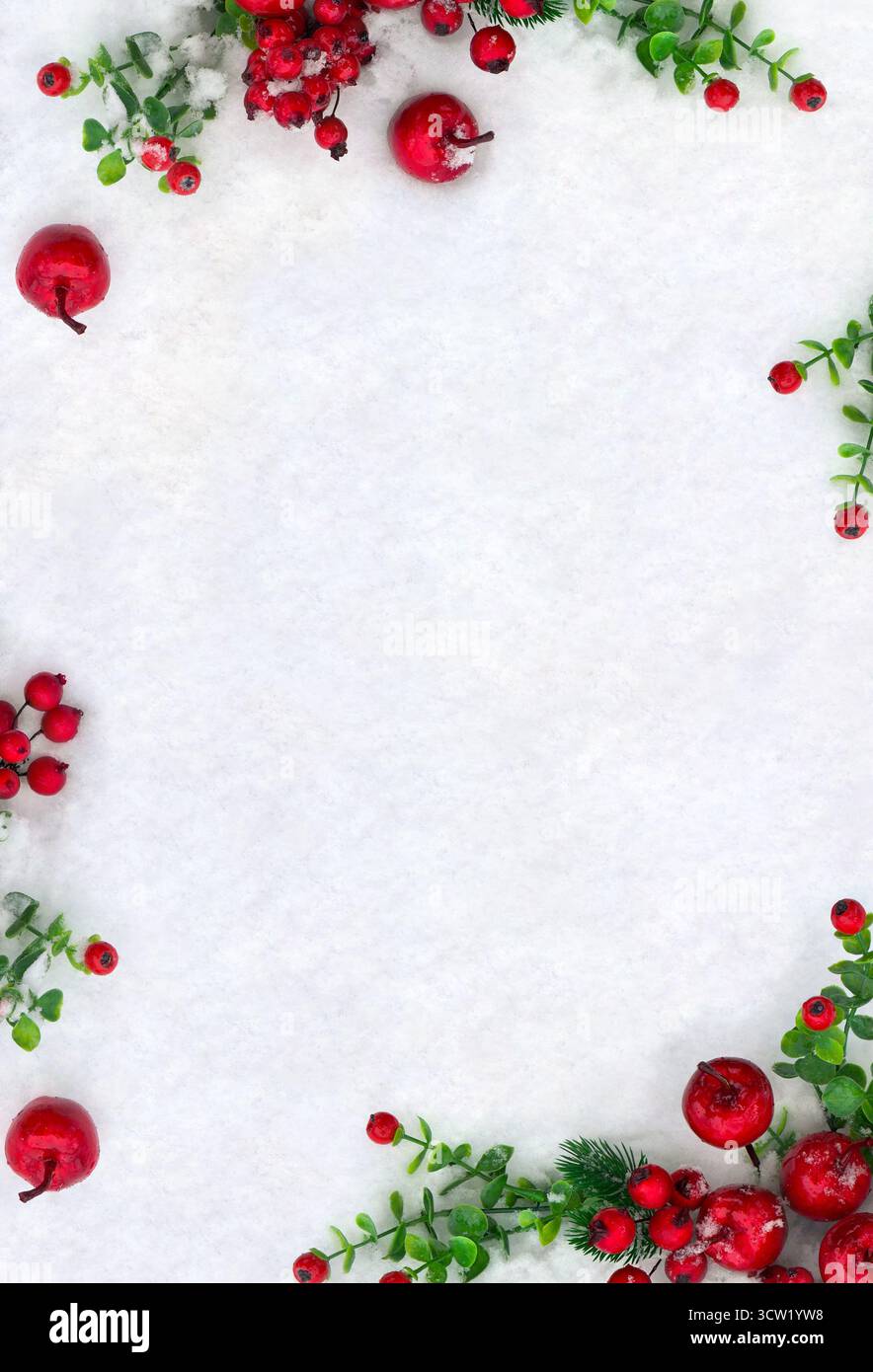 Decorazione natalizia. Albero di Natale rami con bacche rosse e mele rosse sulla neve con spazio per testo. Vista dall'alto, disposizione piatta Foto Stock