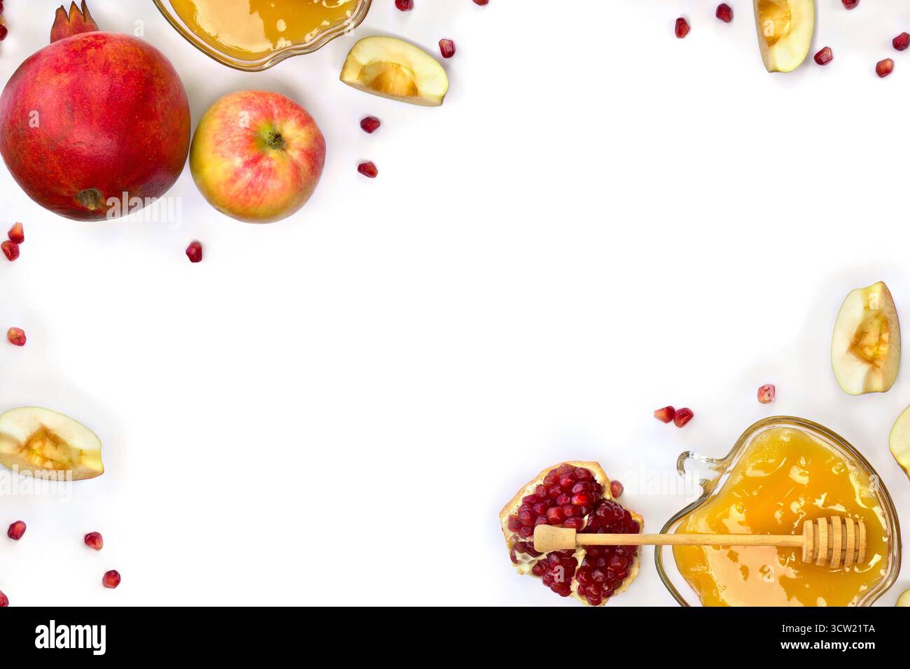 Cornice di miele in un recipiente di vetro, mele rosse, granati, cucchiaia di miele in legno su sfondo bianco con spazio per il testo. Vista dall'alto, disposizione piatta Foto Stock