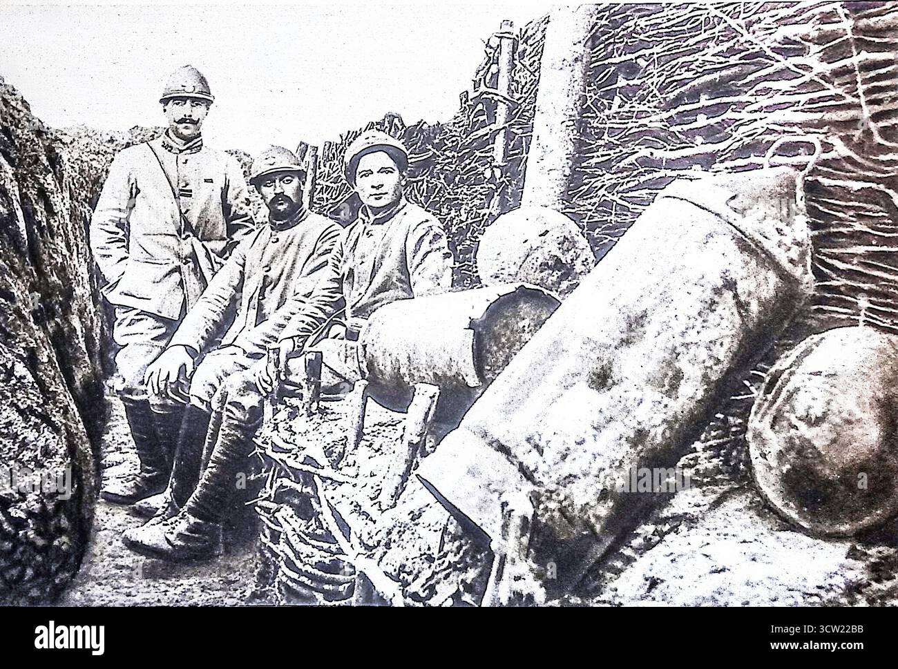 1916 fotografia pubblicata su le Miroir che mostra i soldati francesi in una trincea accanto ai proiettili tedeschi inesplosi di Minenwerfer, soprannominati ìseau ‡ charbon.î questi uomini erano incaricati di rimuovere proiettili pericolosi che non sono riusciti a detonare durante il bombardamento. L'immagine riflette sia i pericoli della vita in trincea che la resilienza delle truppe francesi sul fronte occidentale durante la prima guerra mondiale Foto Stock