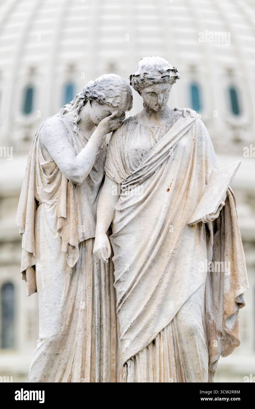 Statua del Monumento alla pace Capitol Hill Washington DC // WASHINGTON DC - la scultura in marmo del dolore e della storia, parte del Monumento alla Pace, è in primo piano su Capitol Hill. Dedicato nel 1878, questo monumento commemora il personale navale morto in mare durante la guerra civile americana. Scolpita da Franklin Simmons, l'opera in marmo bianco include diverse figure allegoriche, con il dolore a sinistra e la storia a destra. L'iconica cupola del Campidoglio degli Stati Uniti è visibile sullo sfondo, un simbolo della democrazia e del governo americani. Il monumento si trova a terra Foto Stock