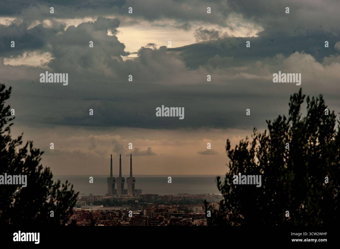 9 ottobre 2025. Barcellona, Spagna: Le nuvole si stagliano all'orizzonte sopra i camini dell'ex centrale termica nota come Tres Xemeneies, vista dalla collina di Turo de la Peira nel nord di Barcellona. Crediti: Jordi Boixareu/Alamy Live News Foto Stock