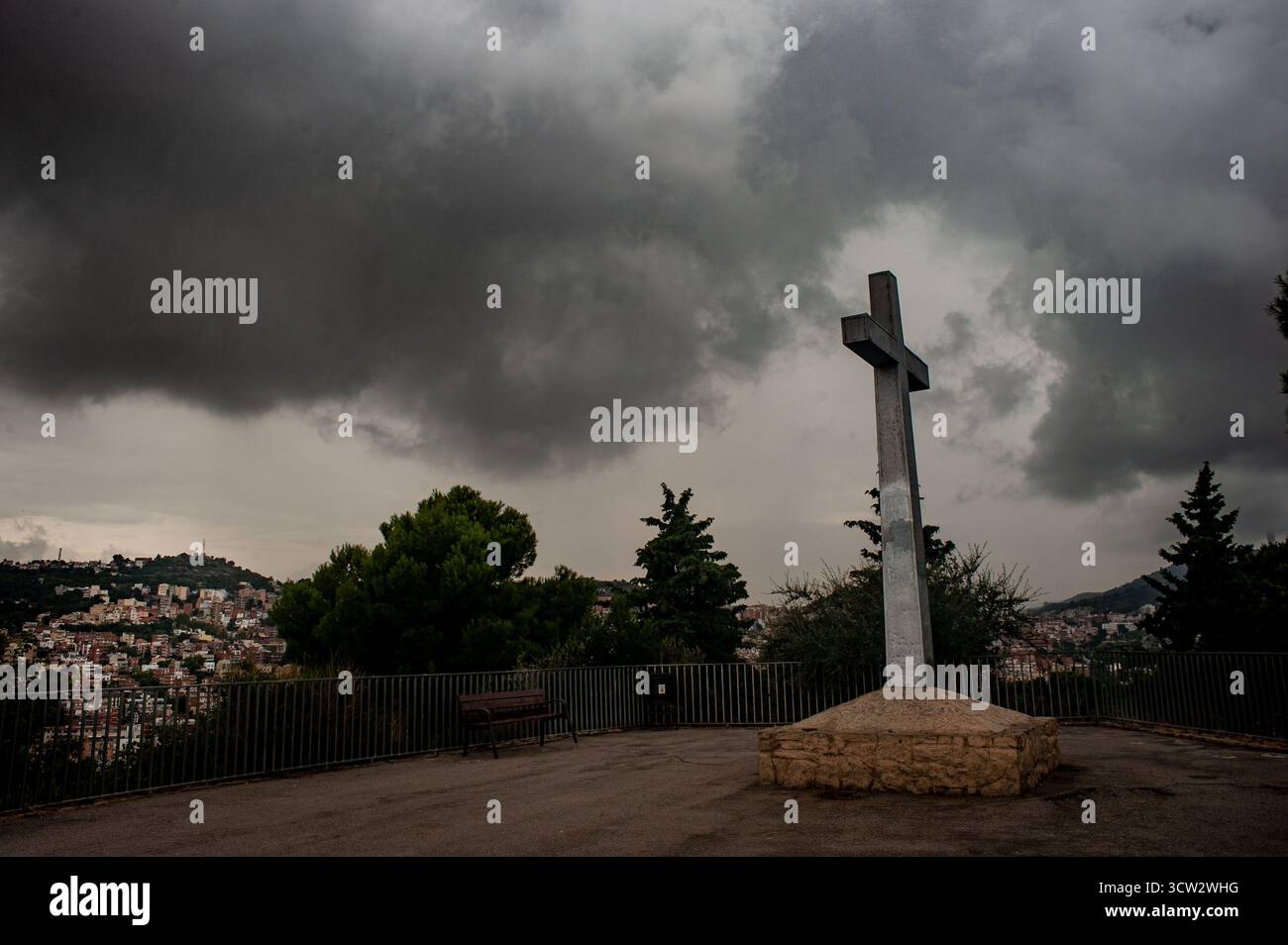 9 ottobre 2025. Barcellona, Spagna: Nuvole di tempesta si riuniscono sopra la croce in cima alla collina Turo de la Peira nel nord di Barcellona. Crediti: Jordi Boixareu/Alamy Live News Foto Stock