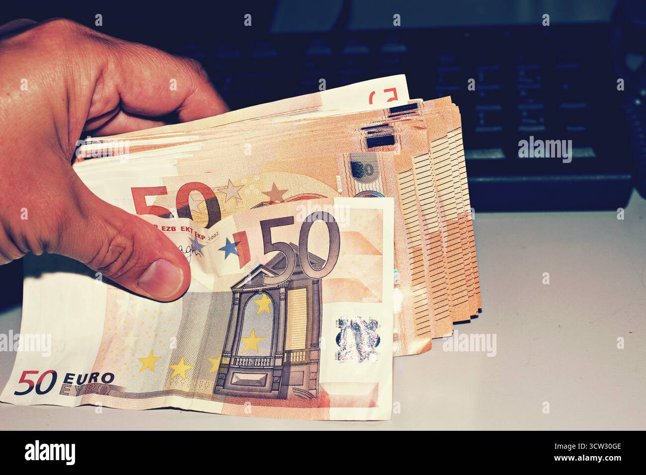 uomo che tiene i soldi davanti a un concetto informatico di internet business Foto Stock