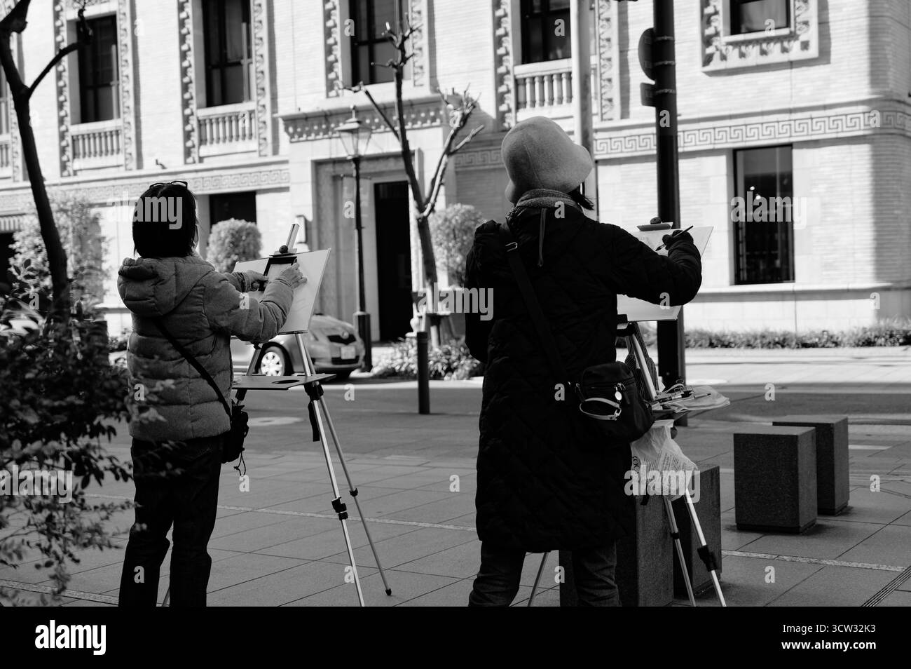 Monocromatico di artisti che si riuniscono in un giorno d'inverno a Osaka per disegnare un edificio storico ornato Foto Stock