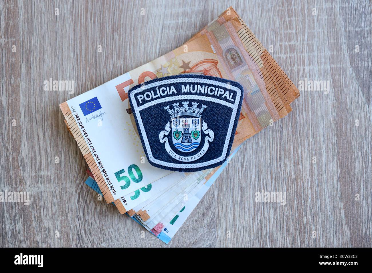 KIEV, UCRAINA - 6 SETTEMBRE 2025 Portogallo patch della polizia municipale su una grande quantità di banconote in euro in primo piano Foto Stock