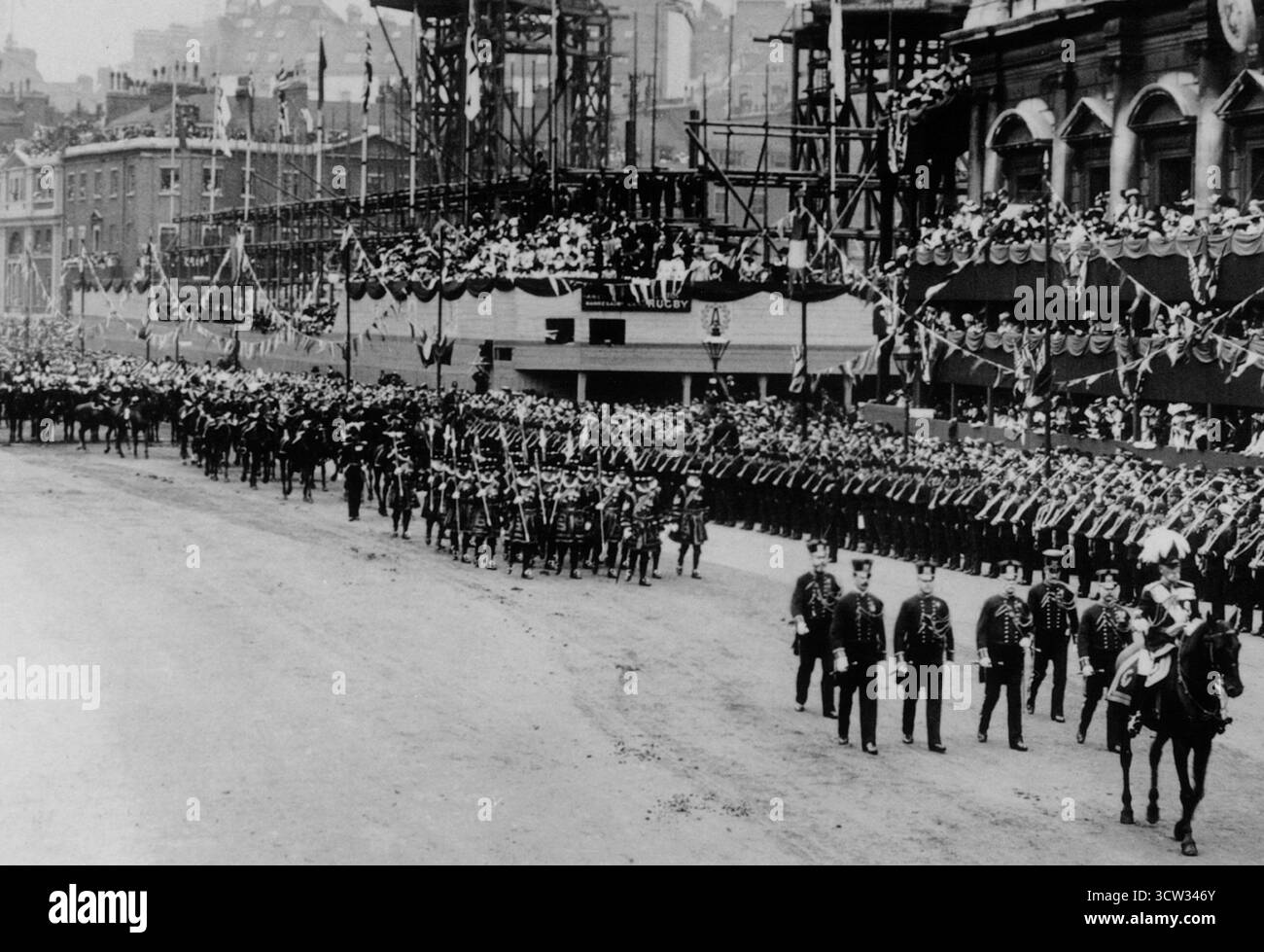 La processione per l'incoronazione di re Edoardo VII passa la costruzione dell'edificio Old War Office a Whitehall, Londra nel 1902. L'Old War Office fu costruito nel 1902 per lo Stato maggiore imperiale ed era centrale per le operazioni. L'edificio fu un punto focale per la pianificazione militare durante i principali conflitti del XX secolo, ospitando numerosi segretari di Stato, tra cui Sir Winston Churchill. Foto Stock