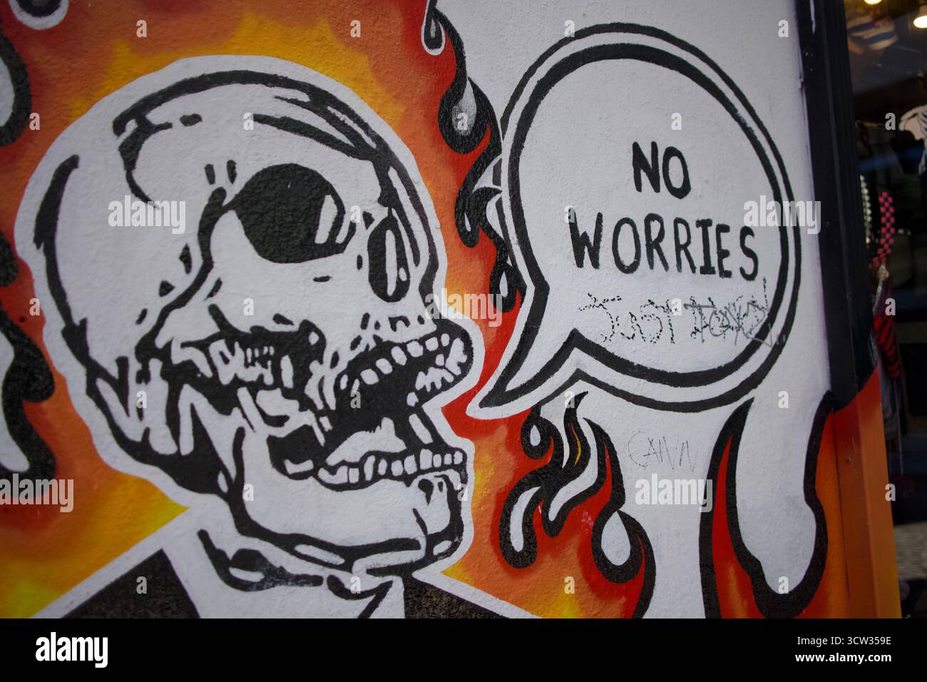 Street art urbana di uno scheletro con una bolla di discorso "non preoccuparti" a Dublino, Irlanda Foto Stock