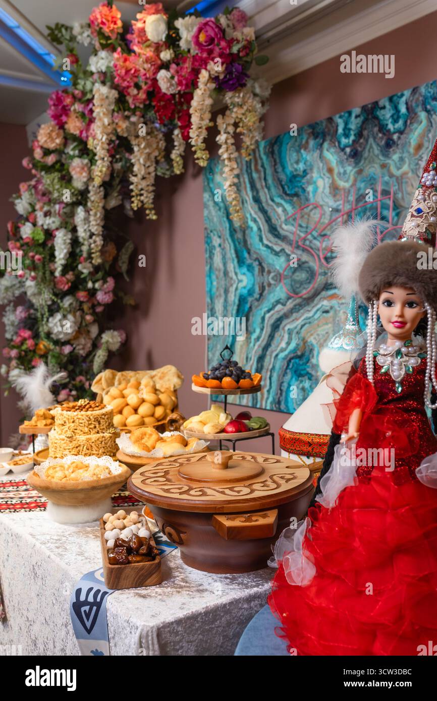 Tavolo festivo con fiori e bambola in rosso - lusso, dettagli e atmosfera celebrativa Foto Stock