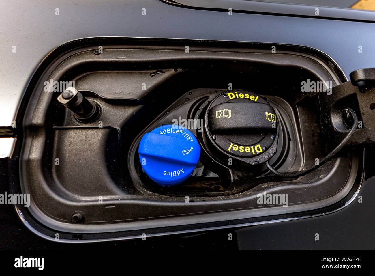 Primo piano dell'area del bocchettone di rifornimento del carburante di un'auto che mostra i tappi del gasolio e dell'AdBlue. Concetto di moderna tecnologia dei motori diesel, riduzione delle emissioni e Foto Stock