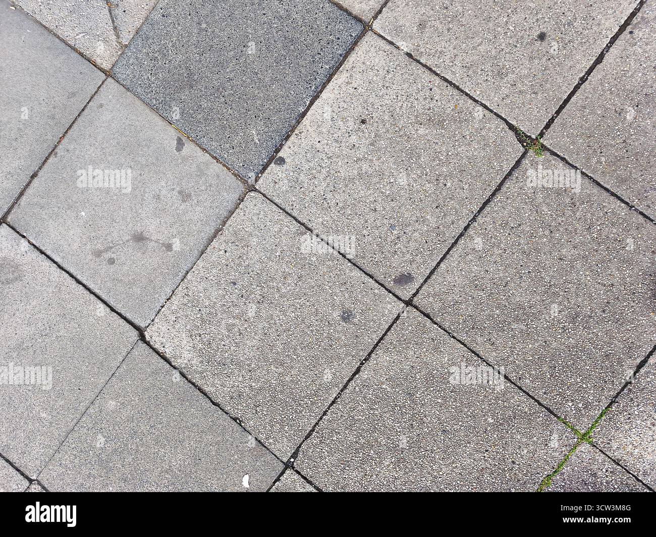 Schema diagonale di pietre di pavimentazione grigie ruvide che creano uno sfondo astratto della superficie ruvida all'aperto Foto Stock