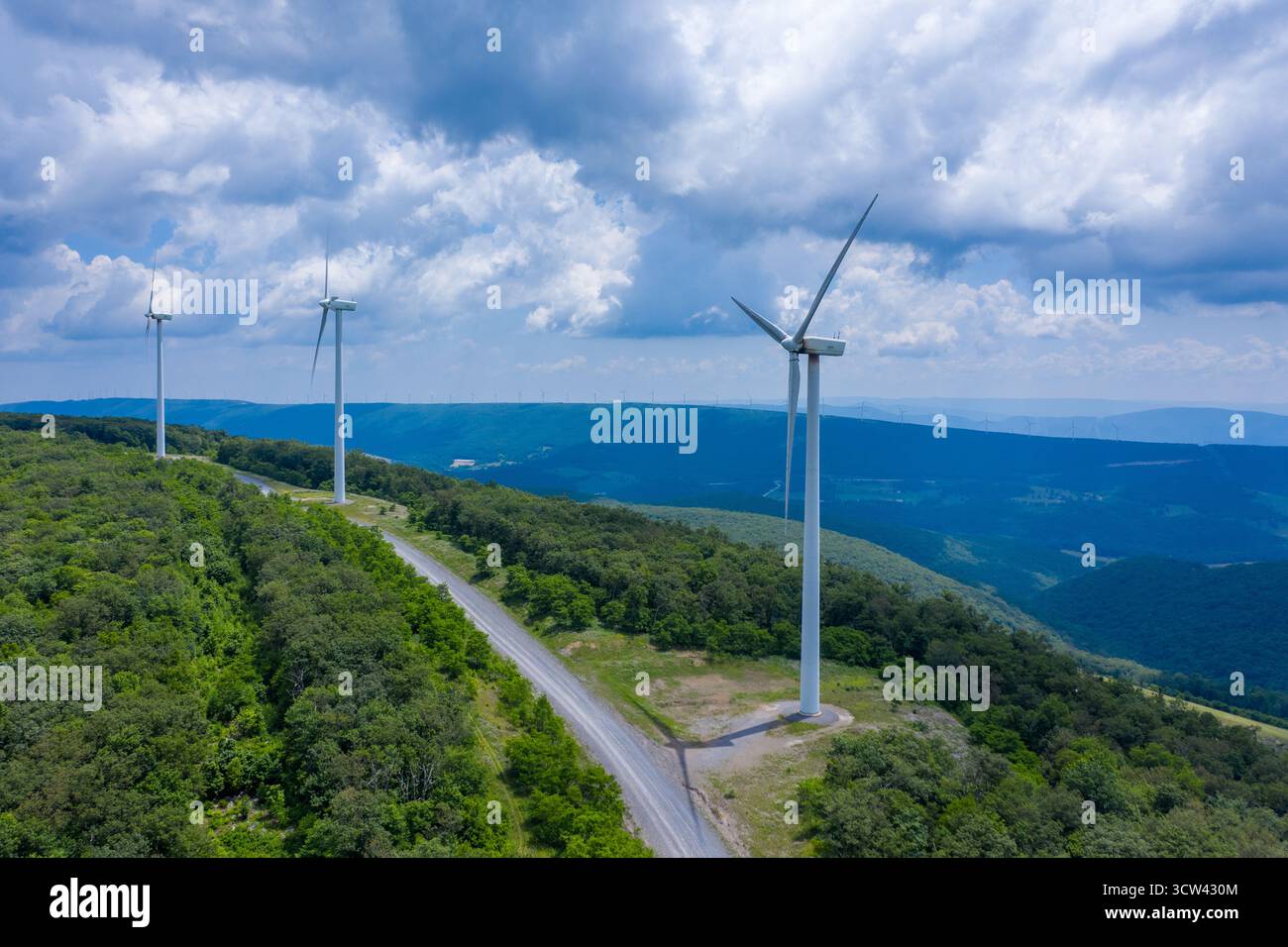 Vista aerea delle turbine eoliche che si innalzano in alto contro il cielo e si affacciano sulla lussureggiante vegetazione delle montagne, Mount Storm, West Virginia, Stati Uniti. Foto Stock