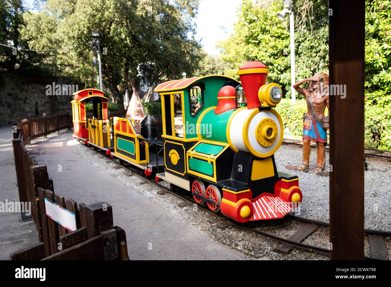 Parco divertimenti per bambini luminoso e colorato, in treno, immerso nel verde Foto Stock
