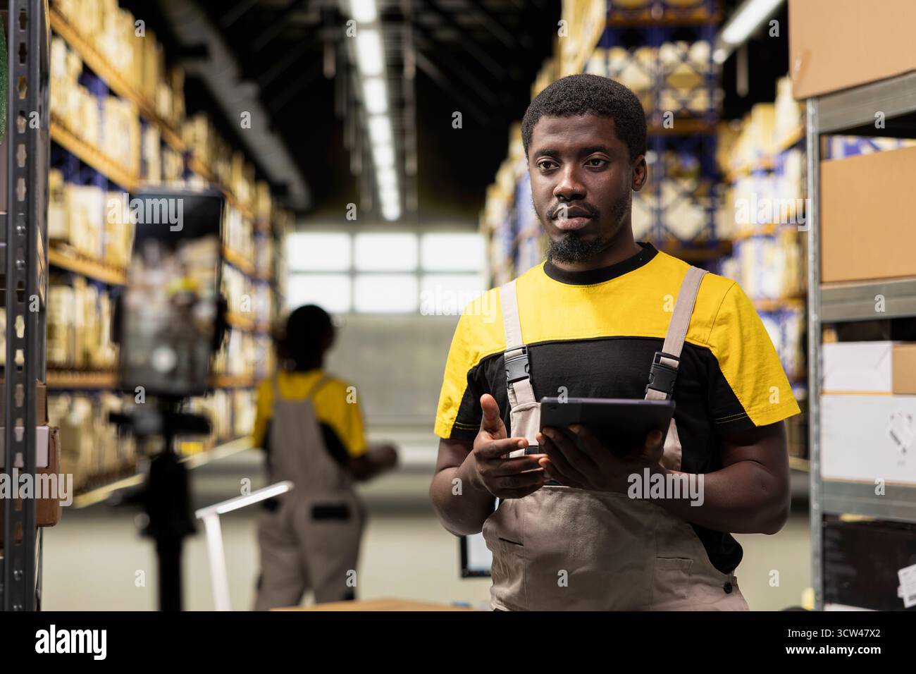 Il personale del centro di evasione ordini nero registra un vlog pubblicitario per promuovere attività industriali e di vendita al dettaglio su larga scala, mostrando il flusso di lavoro della consegna dei pacchi. Video pubblicitario commerciale per grandi aziende. Foto Stock