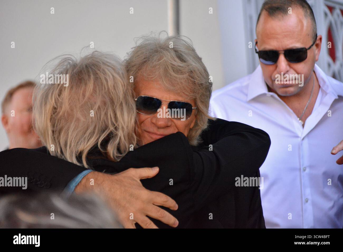 Jon Bon Jovi abbraccia Rick Savage sul palco durante la cerimonia della star della Hollywood Walk of Fame dei DEF Leppard, tenutasi il 9 ottobre 2025, in Vine Street di fronte all'edificio Capitol Records a Los Angeles, California. Foto Stock