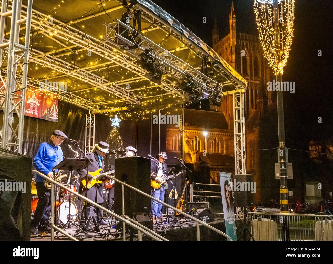Worcestershire, Inghilterra - novembre 29 2024: Una band locale suona su un palcoscenico temporaneo, in Cathedral Square, di fronte al monumento storico nell'orecchio Foto Stock