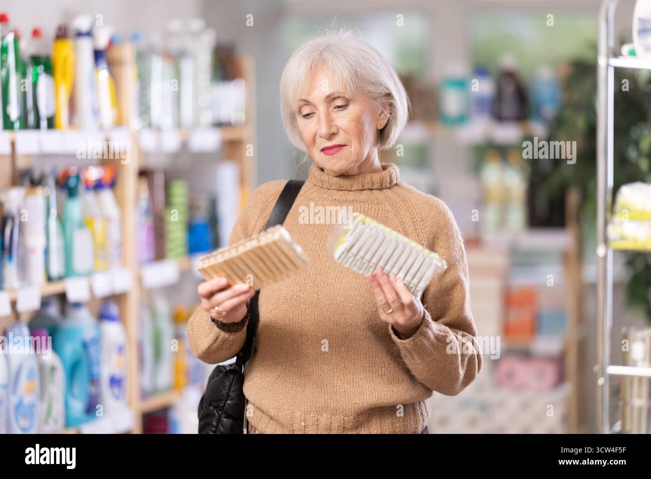 Donna che sceglie un set di clothespins nel negozio Foto Stock