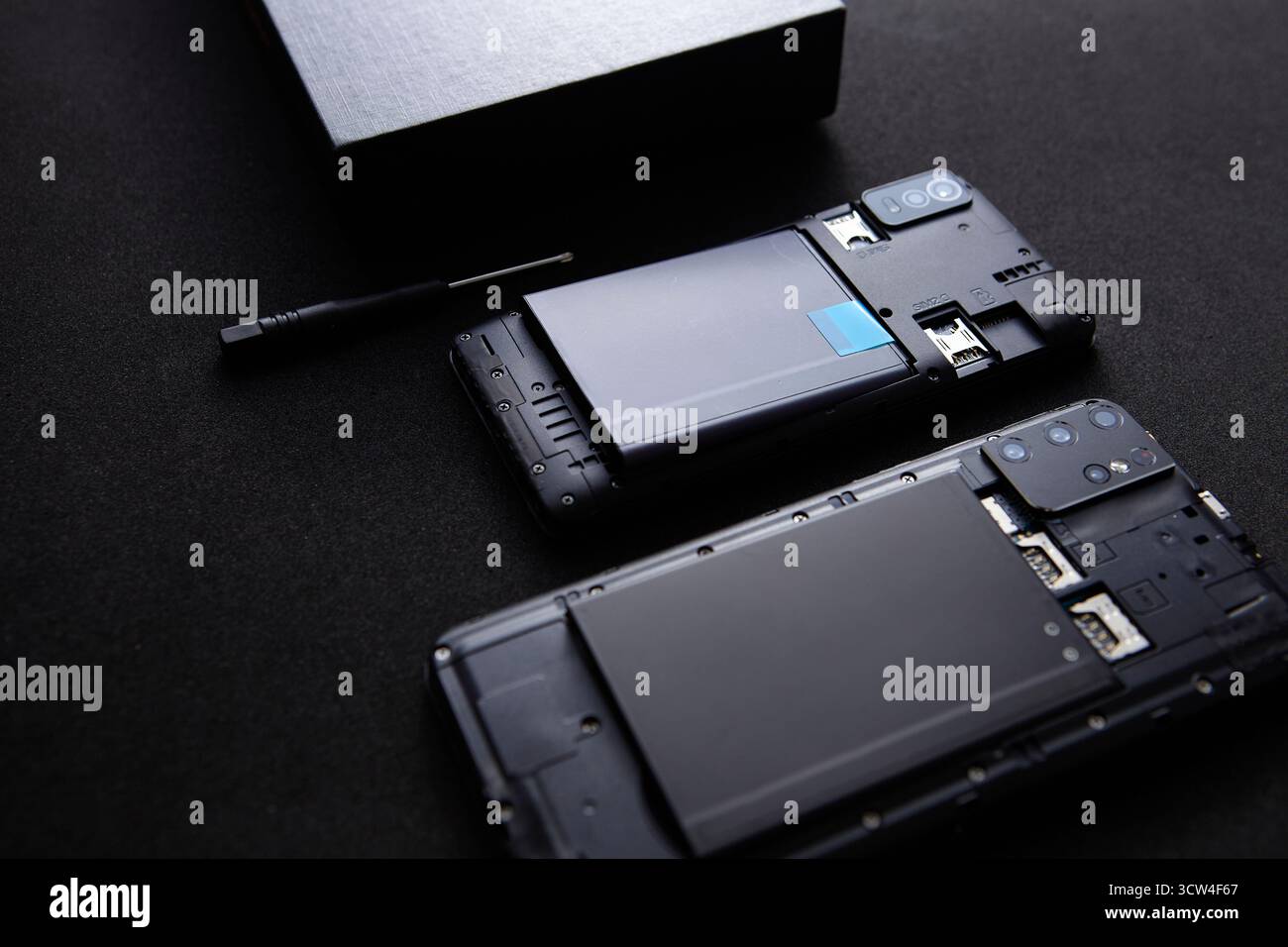 Primo piano di uno smartphone smontato con attrezzi di riparazione posizionati nelle vicinanze. L'immagine di questo studio macro rappresenta la moderna manutenzione tecnologica e la repa di gadget Foto Stock