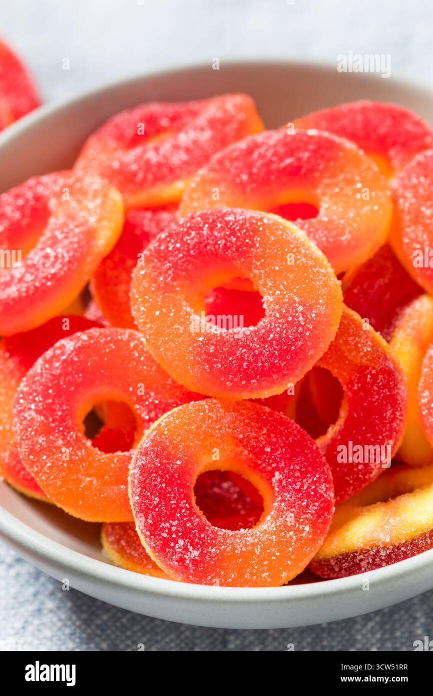 Dolce caramelle rotonde dell'anello di pesca in una ciotola con zucchero Foto Stock