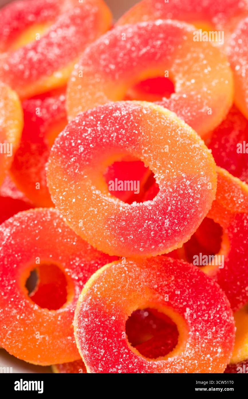 Dolce caramelle rotonde dell'anello di pesca in una ciotola con zucchero Foto Stock