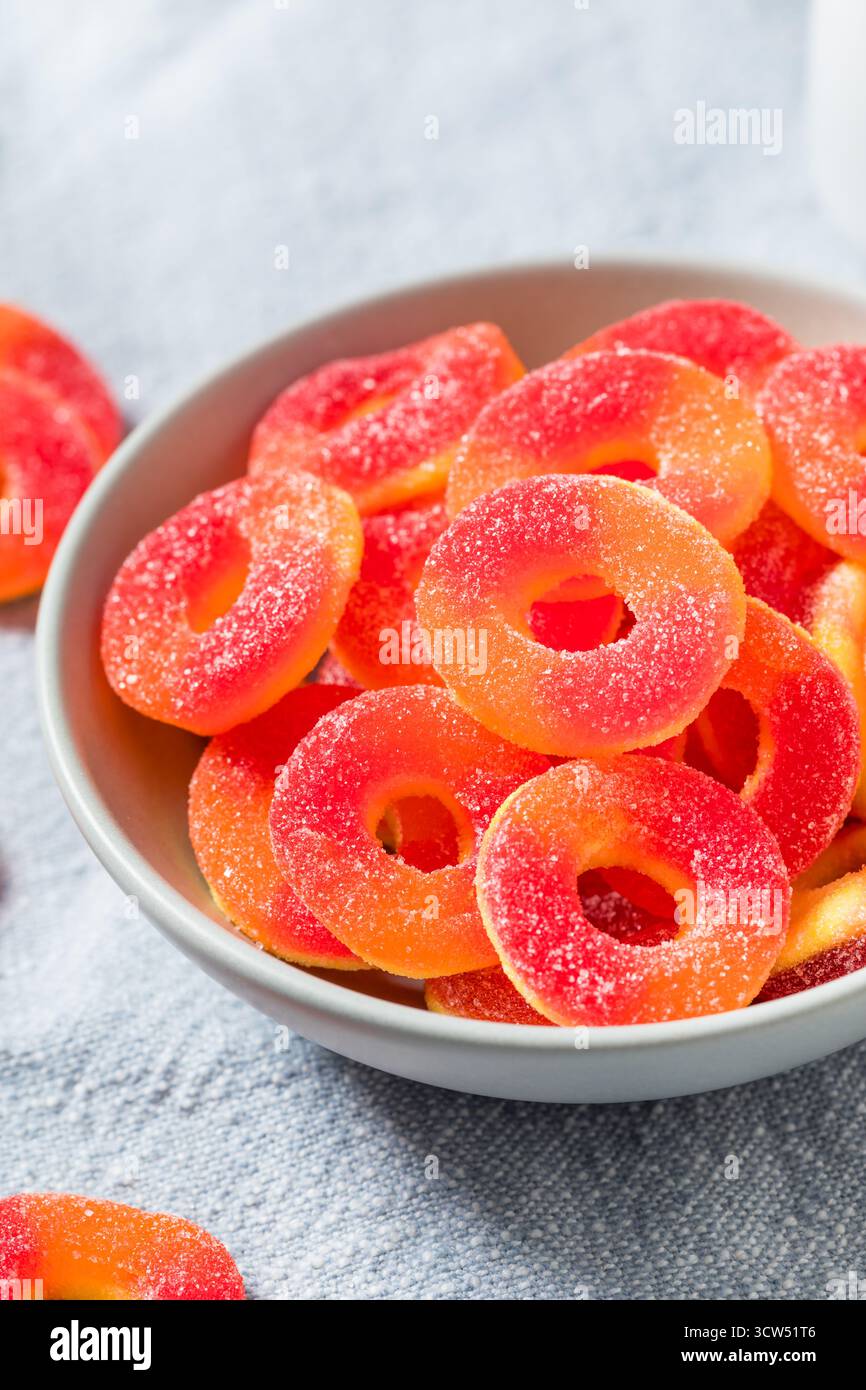 Dolce caramelle rotonde dell'anello di pesca in una ciotola con zucchero Foto Stock