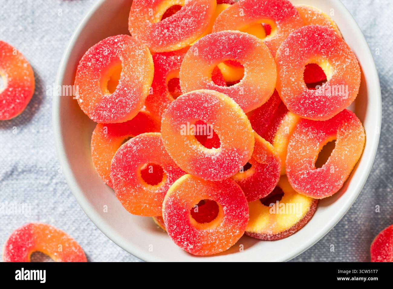 Dolce caramelle rotonde dell'anello di pesca in una ciotola con zucchero Foto Stock