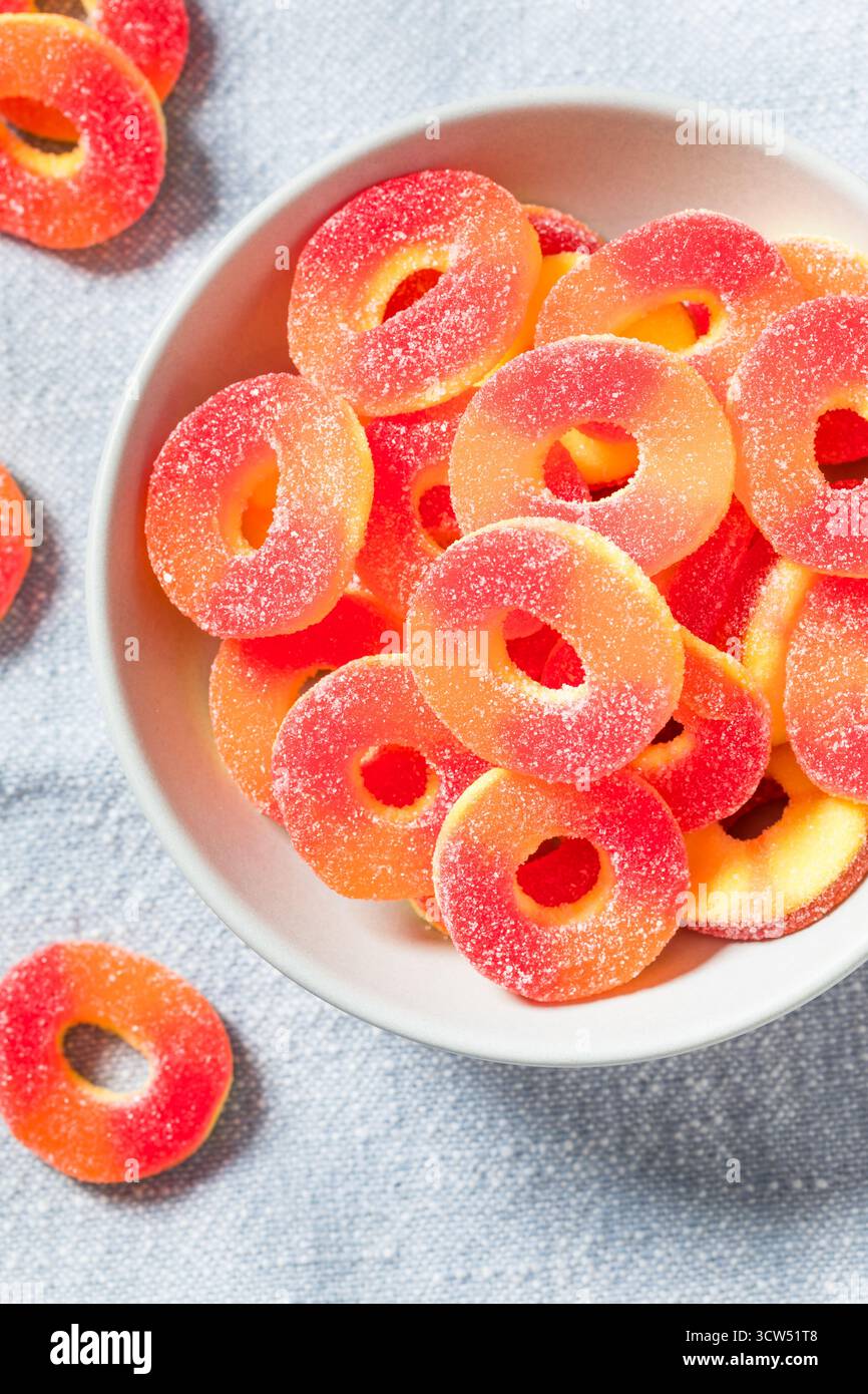 Dolce caramelle rotonde dell'anello di pesca in una ciotola con zucchero Foto Stock