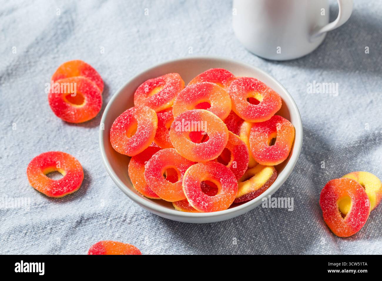 Dolce caramelle rotonde dell'anello di pesca in una ciotola con zucchero Foto Stock