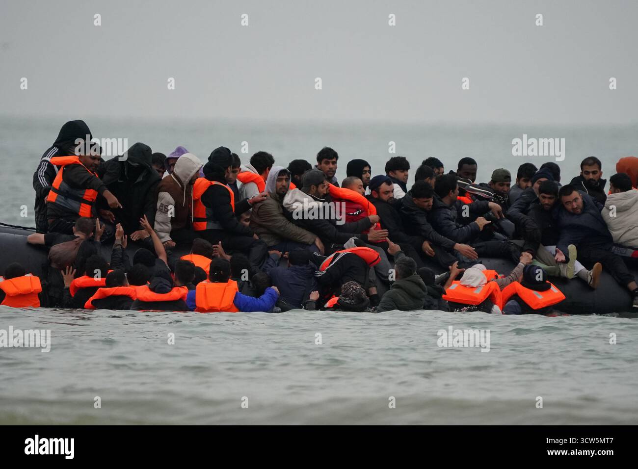 La gente pensata come migranti si tuffò in mare per salire a bordo di una piccola barca a Gravelines, in Francia. Data foto: Venerdì 10 ottobre 2025. Foto Stock
