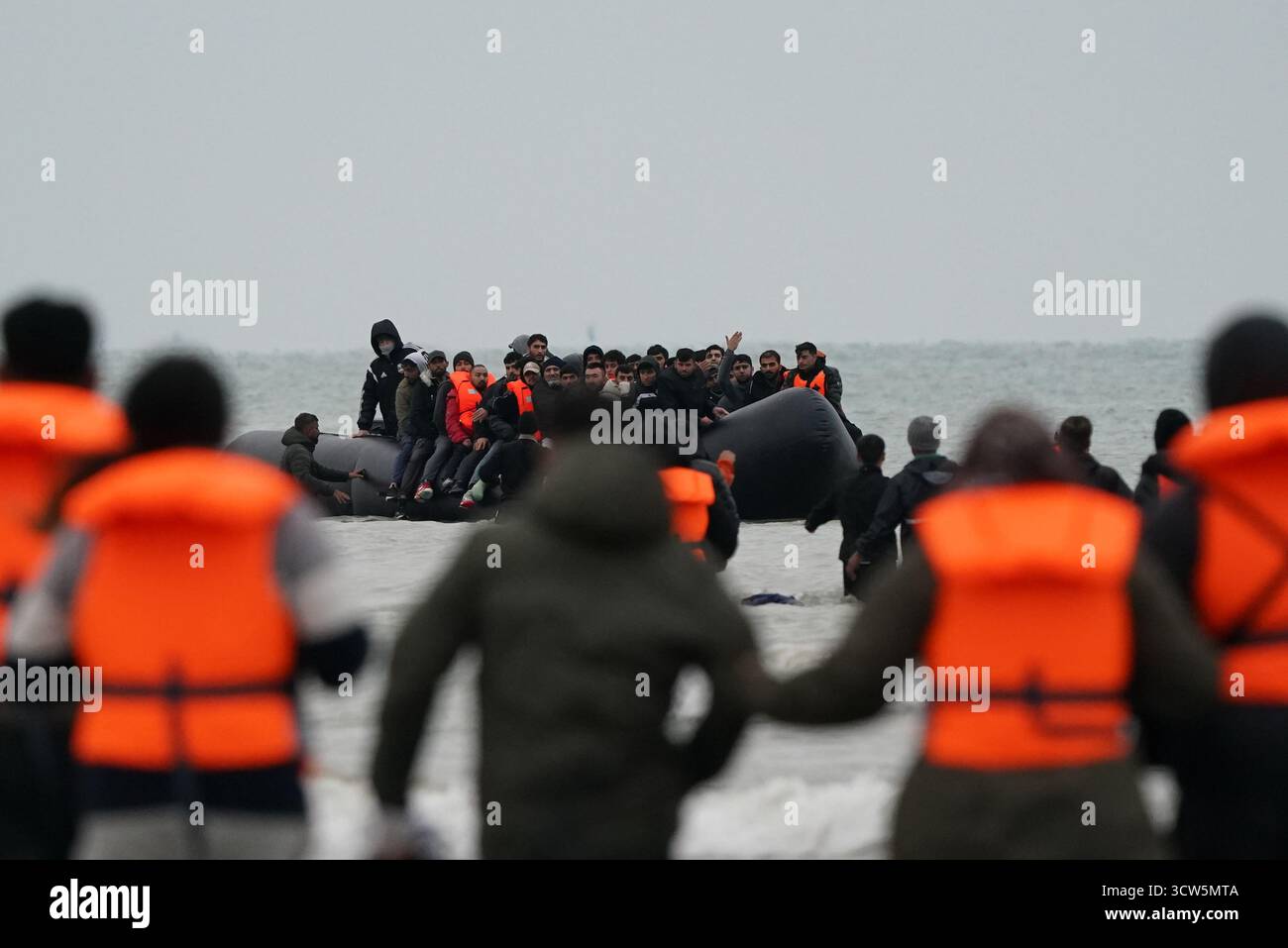 La gente pensata come migranti si tuffò in mare per salire a bordo di una piccola barca a Gravelines, in Francia. Data foto: Venerdì 10 ottobre 2025. Foto Stock
