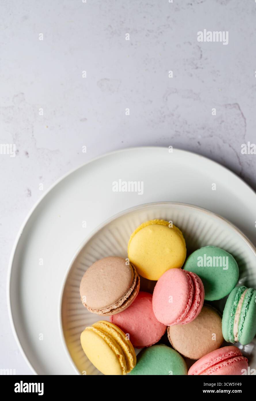 Vista dall'alto primo piano di macaron colorati su sfondo bianco. Foto Stock