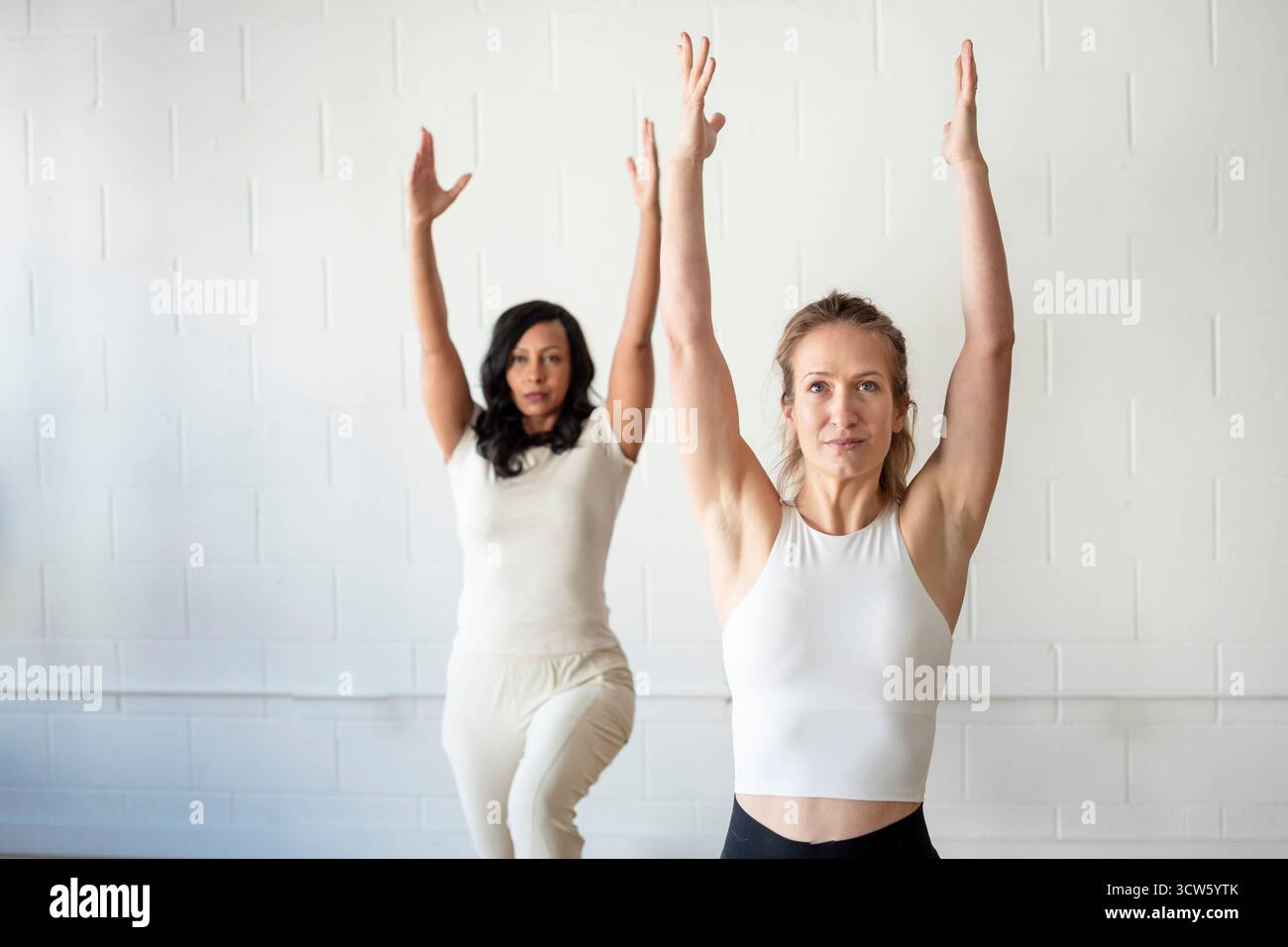 Donne mirate che mantengono la posizione di affondo in una lezione di fitness Foto Stock