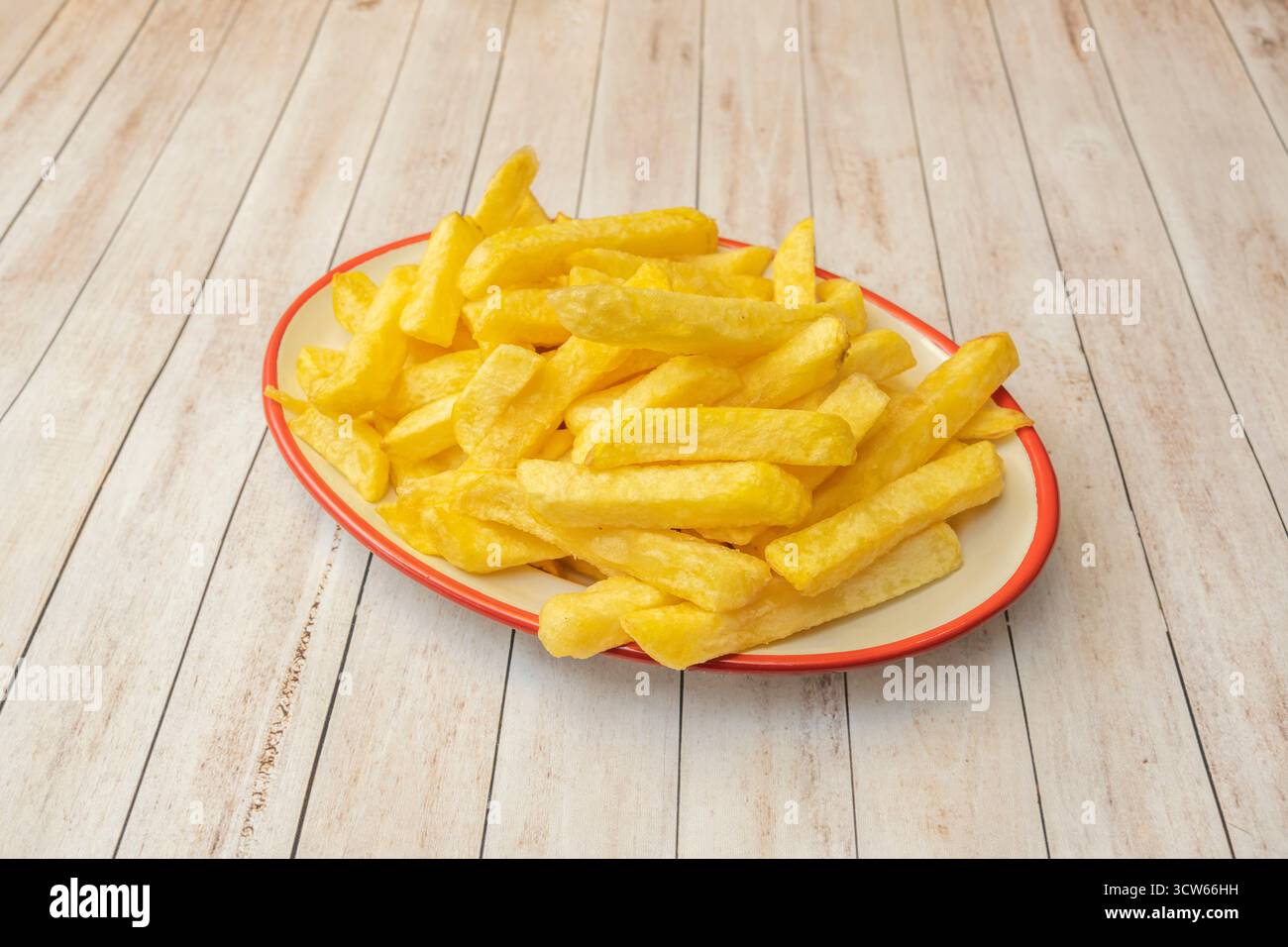 Le patatine tradizionali tagliate in bastoncini spessi, fritte alla perfezione e cosparse di sale marino friabile Foto Stock
