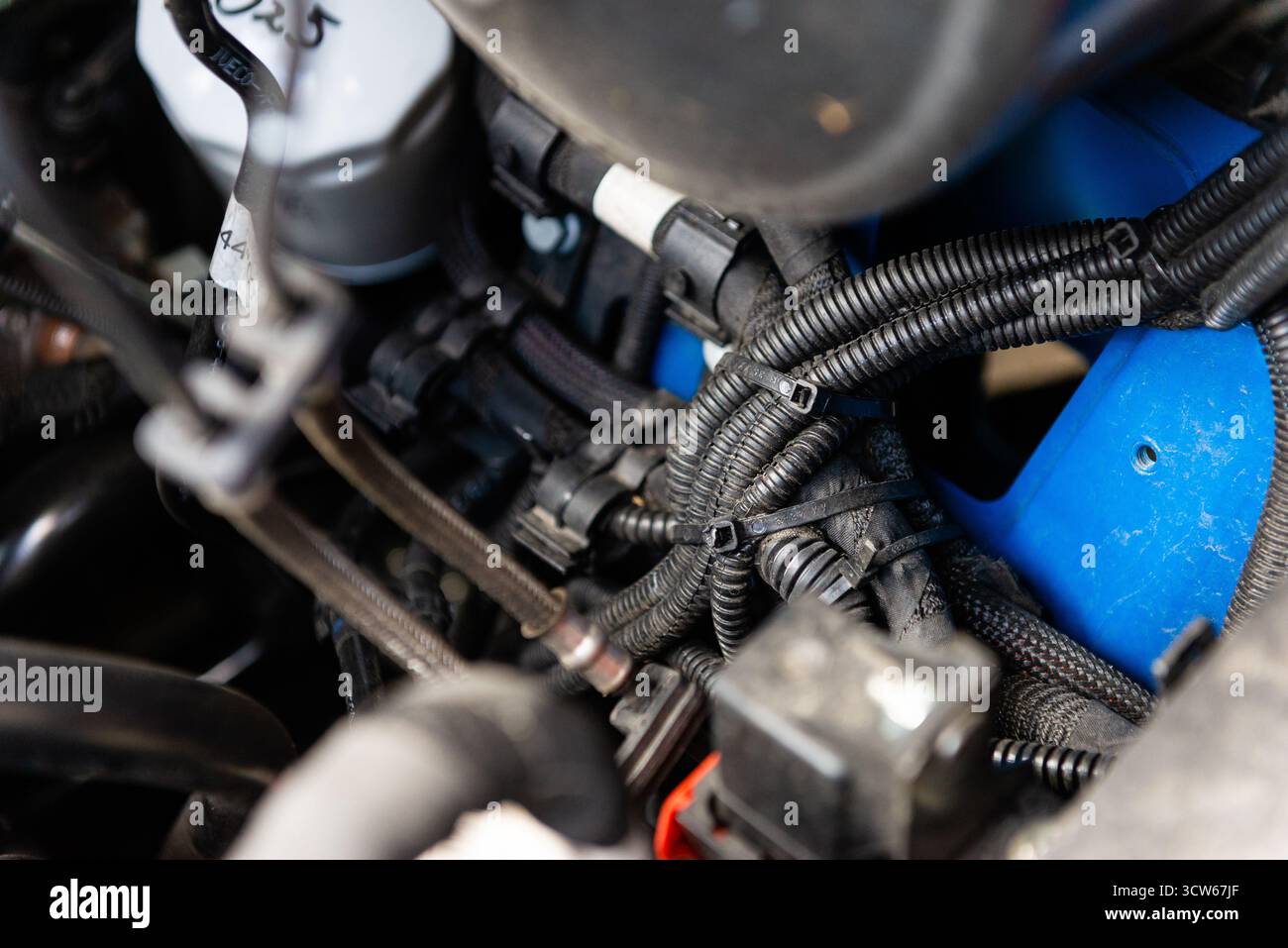 Primo piano del motore dell'auto con parti metalliche, tubi e collegamenti visibili che mostrano dettagli meccanici. Foto Stock