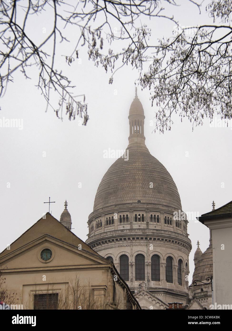 Basilica Sacré-Cœur nella nebbia parigina pesante - dettaglio architettonico ravvicinato di un edificio con la cupola principale e la croce della basilica del Sacro-Cœur disapp Foto Stock