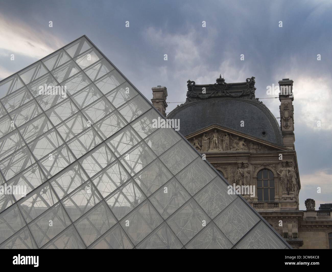 Vetro della Piramide del Louvre e architettura del Palazzo - spettacolare primo piano che mostra la superficie geometrica in vetro della Piramide del Louvre in contrasto con l'ornato Foto Stock