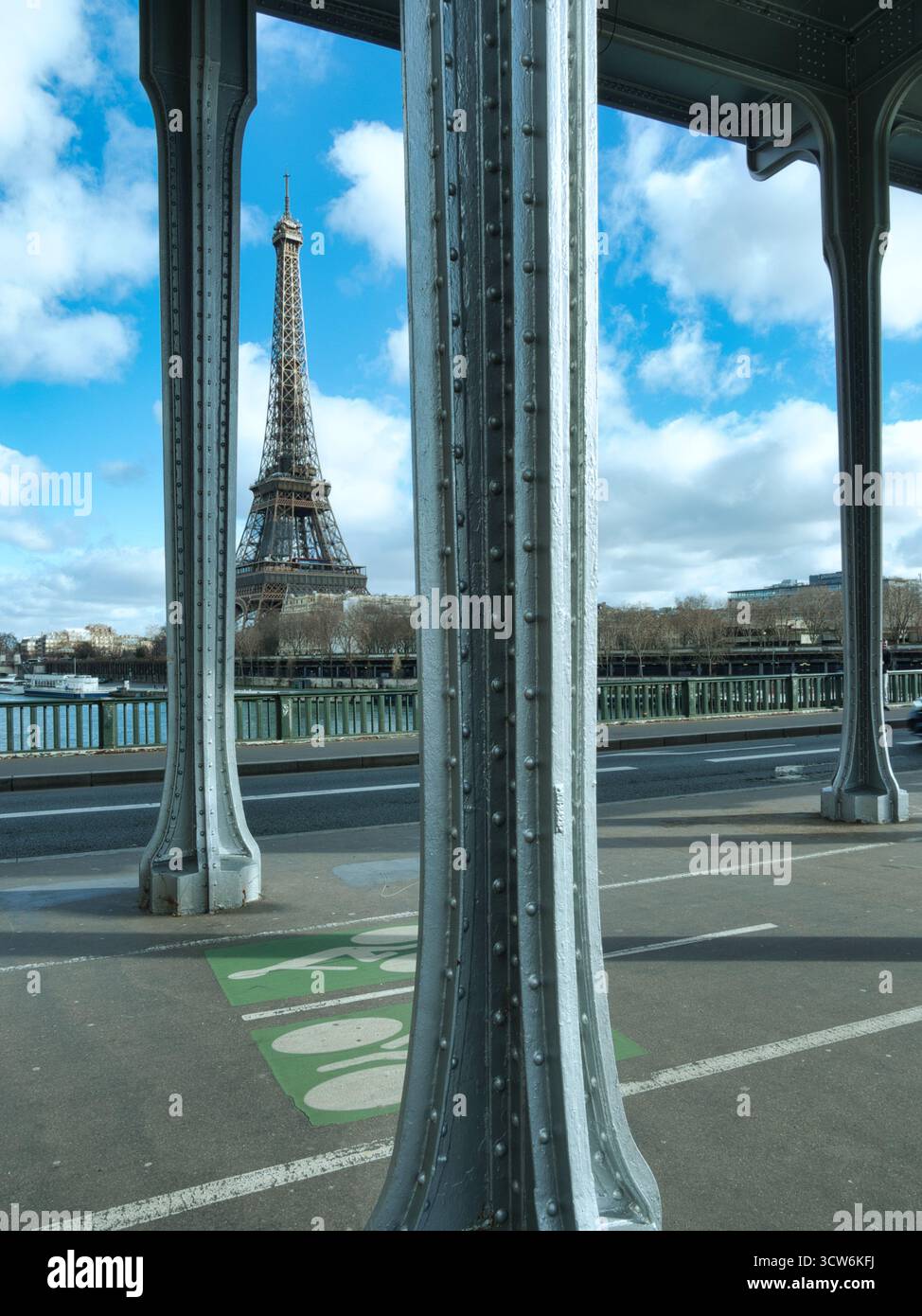 Vista della Torre Eiffel dal ponte Bir-Hakeim - la Torre Eiffel è stata caratterizzata in modo prominente su un cielo blu luminoso con nuvole bianche, incorniciata dal metallo grigio Foto Stock