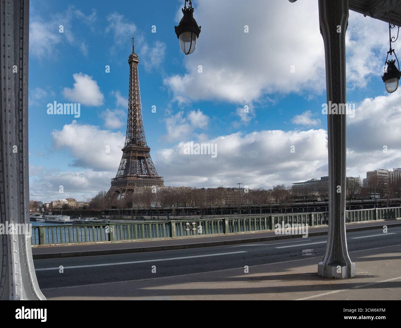 Vista della Torre Eiffel dal ponte Bir-Hakeim - la Torre Eiffel è stata caratterizzata in modo prominente su un cielo blu luminoso con nuvole bianche, incorniciata dal metallo grigio Foto Stock
